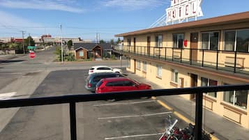 A motel with a sign reading "ARREZ MOTEELK" and a parking lot with several cars and motorcycles.