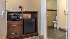 A compact kitchenette with a microwave, refrigerator, and coffee maker. - Rodeway Inn Chicago - Evanston (Chicago)