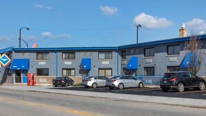 A hotel with three-story blue exterior, parking lot, and a Coca-Cola vending machine. - Rodeway Inn Chicago - Evanston (Chicago)