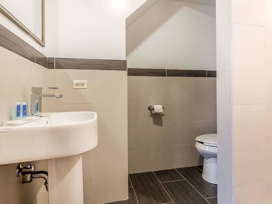 Une salle de bain avec un lavabo, des toilettes et un miroir.