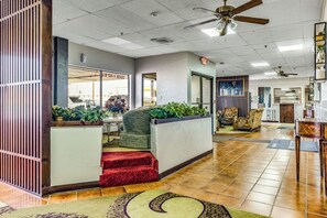 A lobby with a reception desk, seating area, and a view of the parking garage.