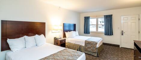 A hotel room with two beds, a nightstand, a lamp, a TV, a window with curtains, and a door.