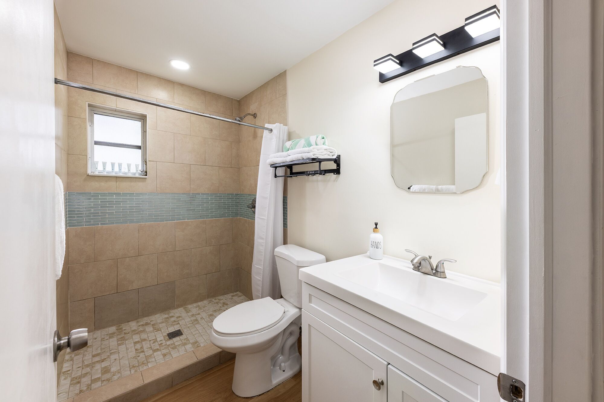 A bathroom with a shower, toilet, and sink.
