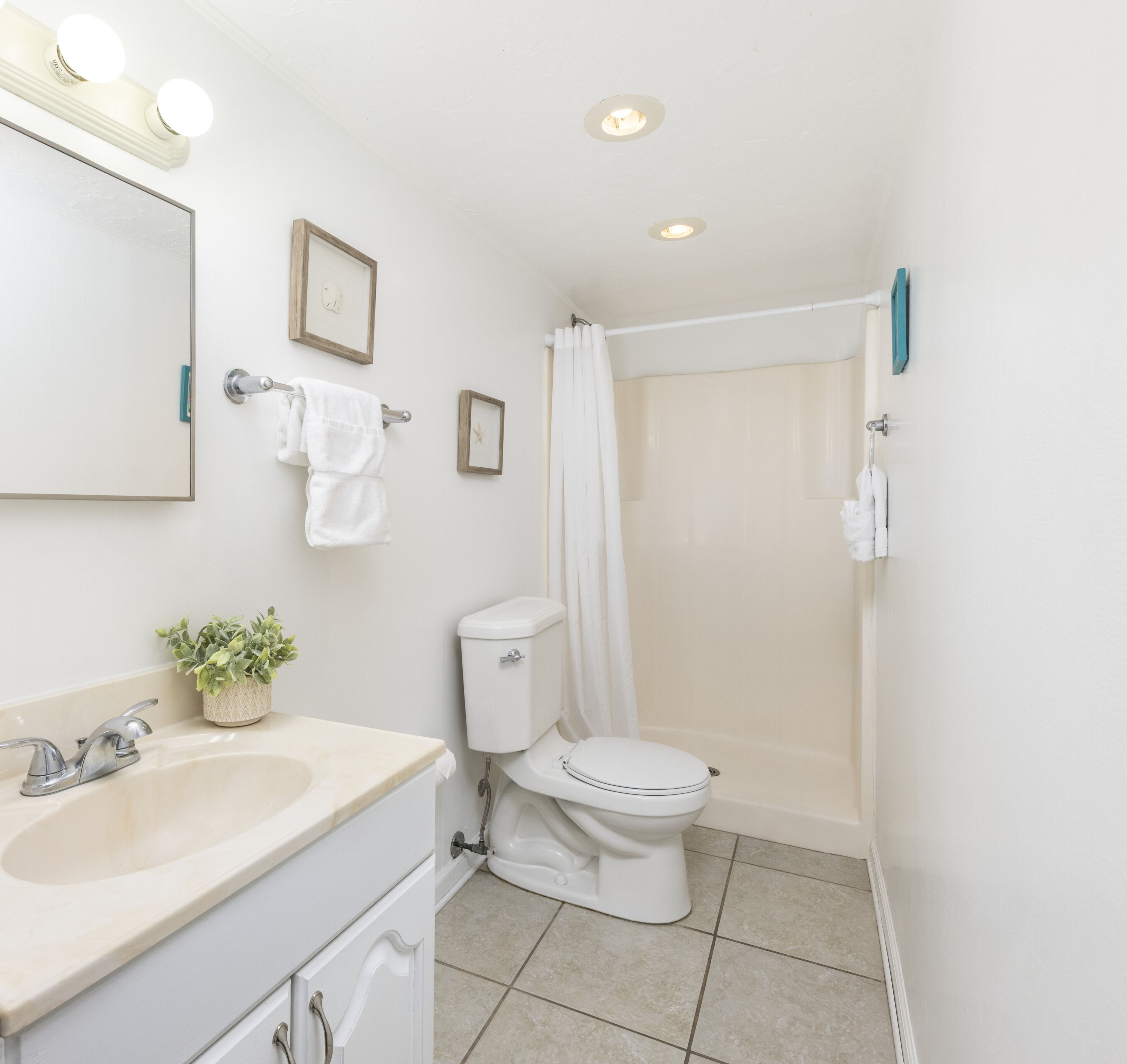 A bathroom with a sink, toilet, and shower.