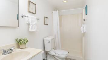 A bathroom with a sink, toilet, and shower.
