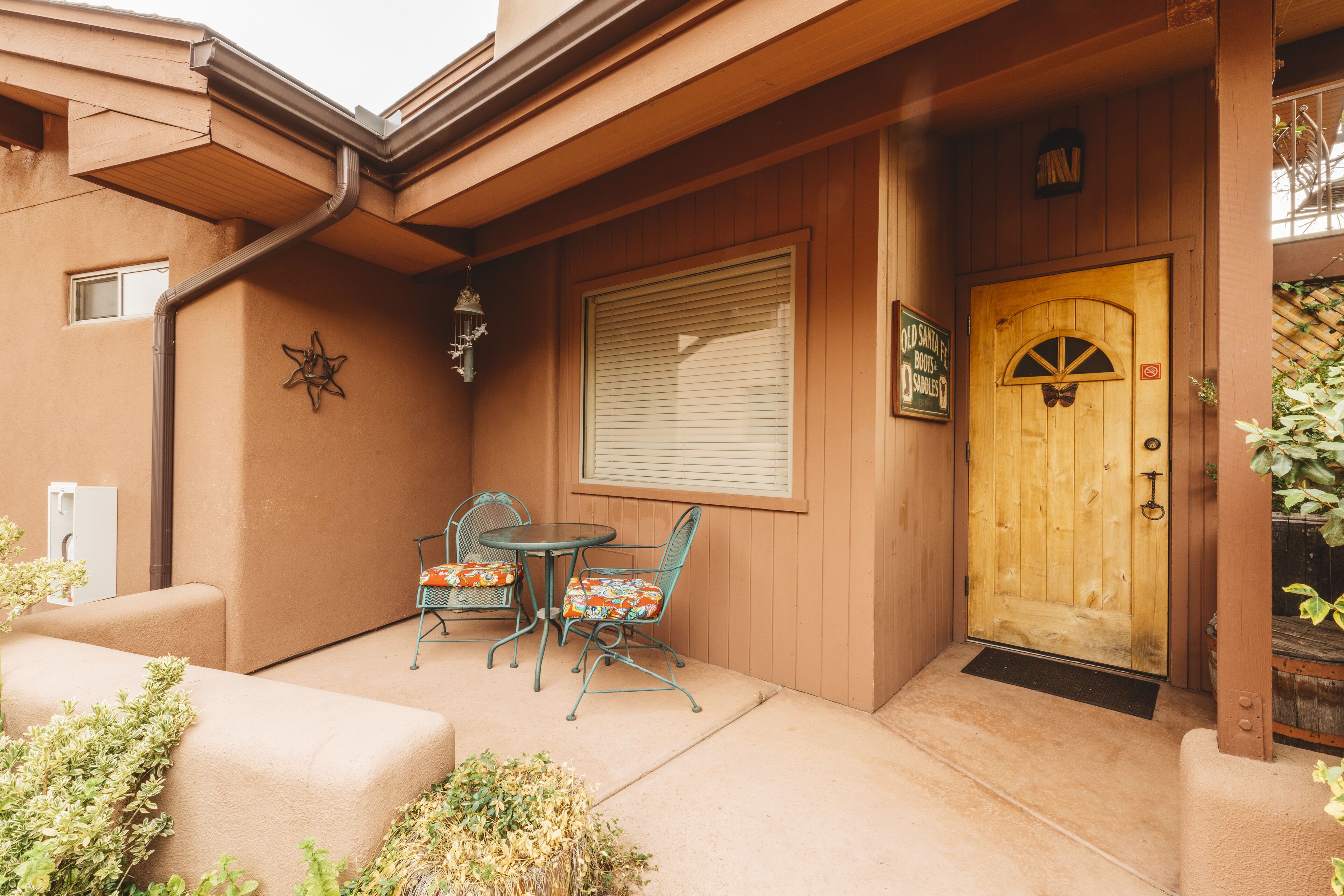A wooden door with a window above it, a small table with chairs, and a decorative star on the wall.