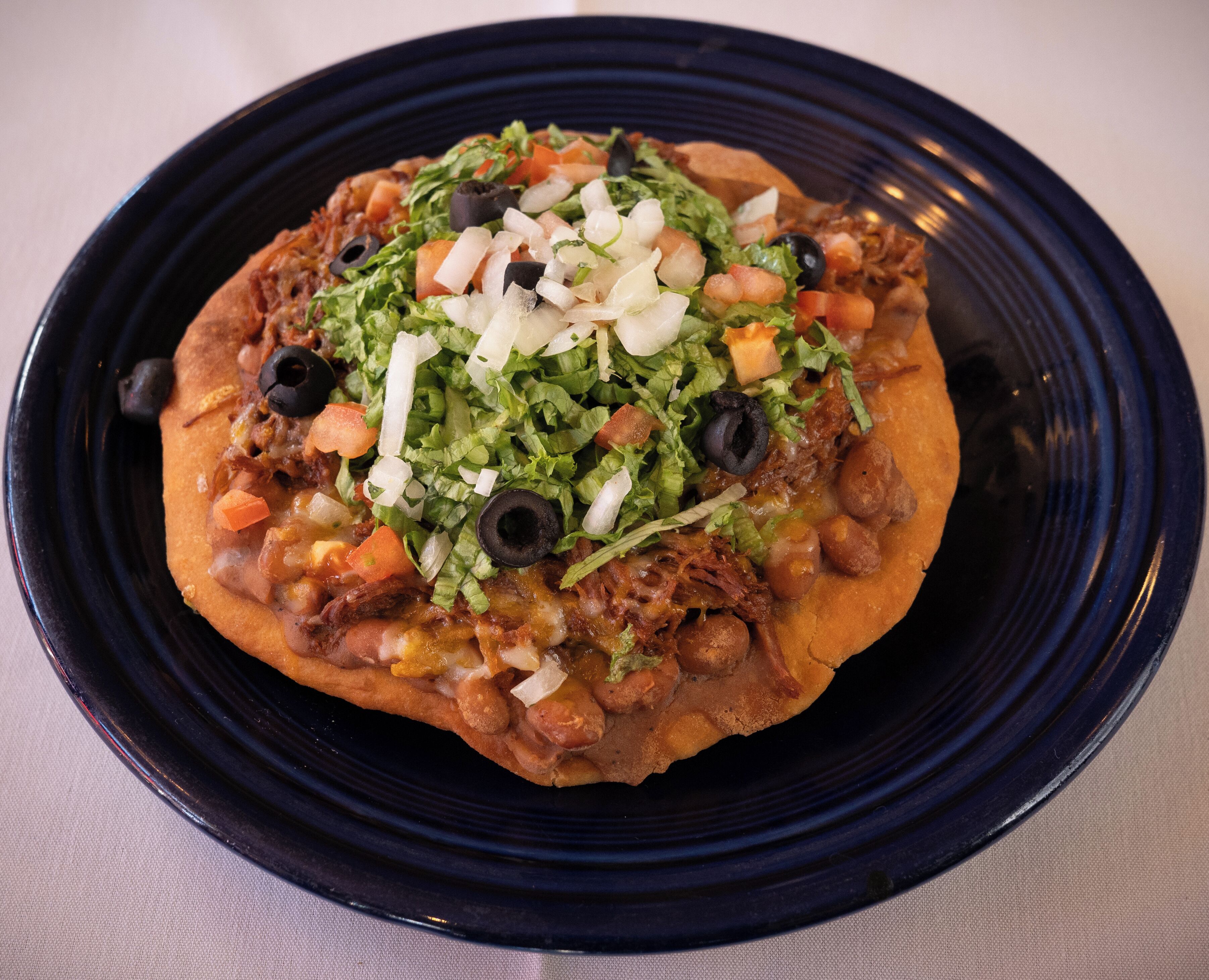 Eine Portion Nachos mit Käse, Bohnen und Gemüse.