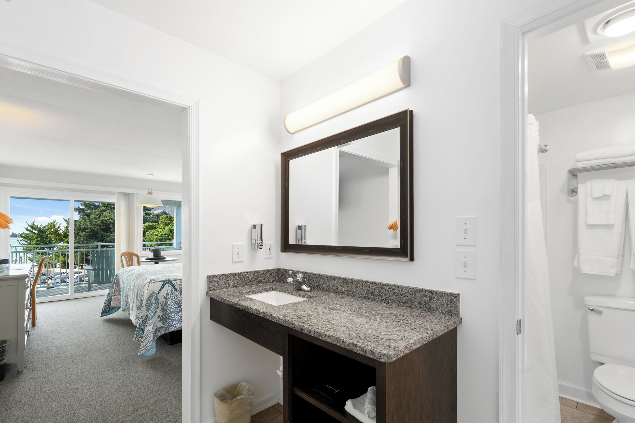 A bathroom with a sink, mirror, and toilet.