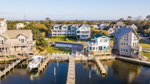A marina with docked boats, a waterfront property with multiple buildings, and a clear view of the surrounding area. - Ocracoke Harbor Inn (Ocracoke)