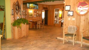 A wooden interior with a dining area, chairs, and a potted plant. - Lakewoods Resort & Lodge (Cable)