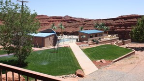 Un hôtel doté d’une piscine, de palmiers et offrant, en arrière-plan, un paysage désertique.