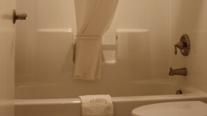 Une salle de bain avec une baignoire, des toilettes et un rideau de douche.