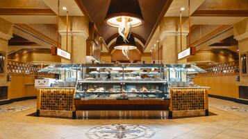 A buffet area with multiple serving stations, a central display case, and a decorative ceiling light.
