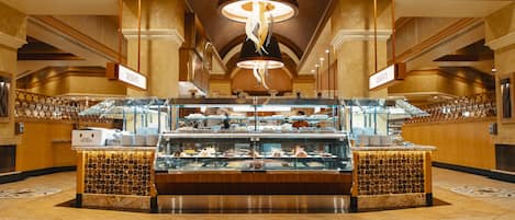 A buffet area with multiple serving stations, a central display case, and a decorative ceiling light.