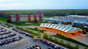 A hotel with a large parking lot, a central courtyard, and a building with a distinctive curved roof. - Four Winds Casino Resort – New Buffalo (New Buffalo)