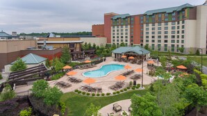 A hotel with a swimming pool, outdoor seating, and a large building with multiple windows. - Four Winds Casino Resort – New Buffalo (New Buffalo)