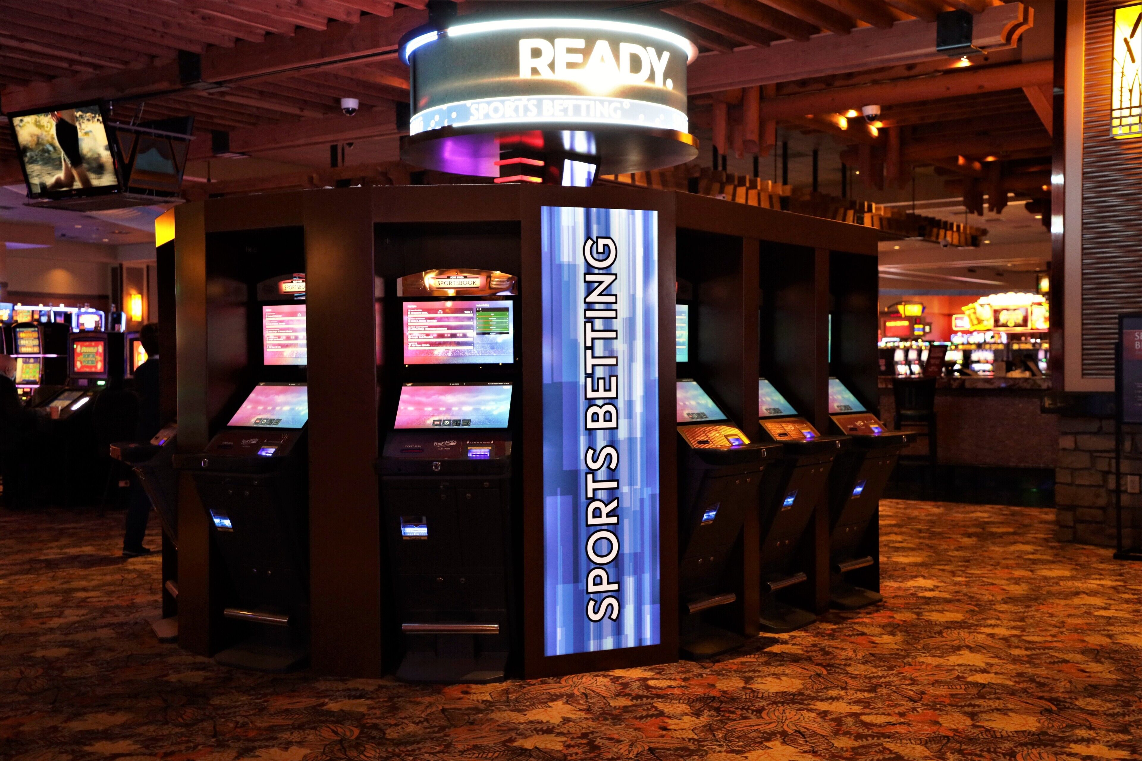 A sports betting area with multiple betting machines and a prominent 'SPORTS BETTING' sign.