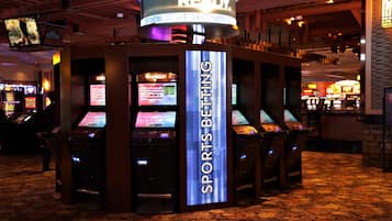 A sports betting area with multiple betting machines and a prominent 'SPORTS BETTING' sign.
