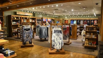 A clothing store with wooden flooring and a sign reading "Pokagon Tribal Artwork".