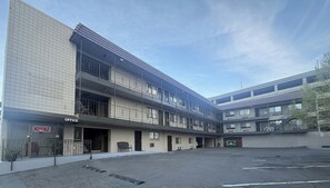 A multi-story building with an office on the ground floor, balconies, and a parking lot. - Red Roof Inn Reno (Reno)
