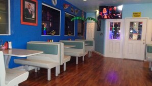 A restaurant interior with booths, a television, and a 'SMILE' sign on the door. - Bayshore Inn (Laughlin)