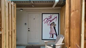 A wooden door with a number 14, a welcome mat, and a poster of 'Dirty Dancing' on the wall.