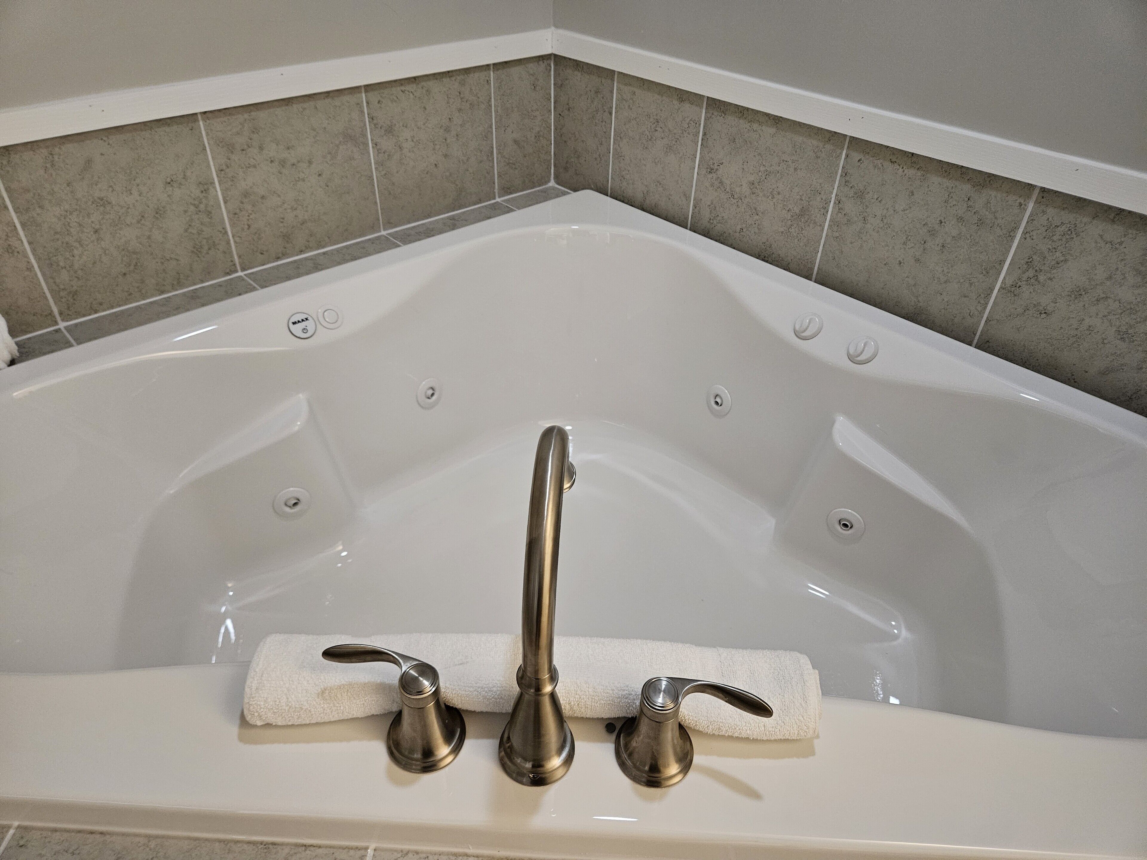 A modern bathroom with a freestanding bathtub, a single faucet, and a towel rack.