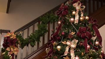 A staircase with a Christmas tree decorated with red and gold ornaments and ribbons.