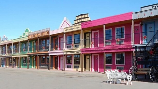A row of colorful buildings with signs for "ATTLEMONS HOTEL" and "ATTLEMONS HOTEL." - Big Texan Motel (Amarillo)