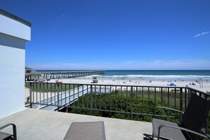 A balcony with a view of a beach and pier. - Silver Gull Motel (Wrightsville Beach)