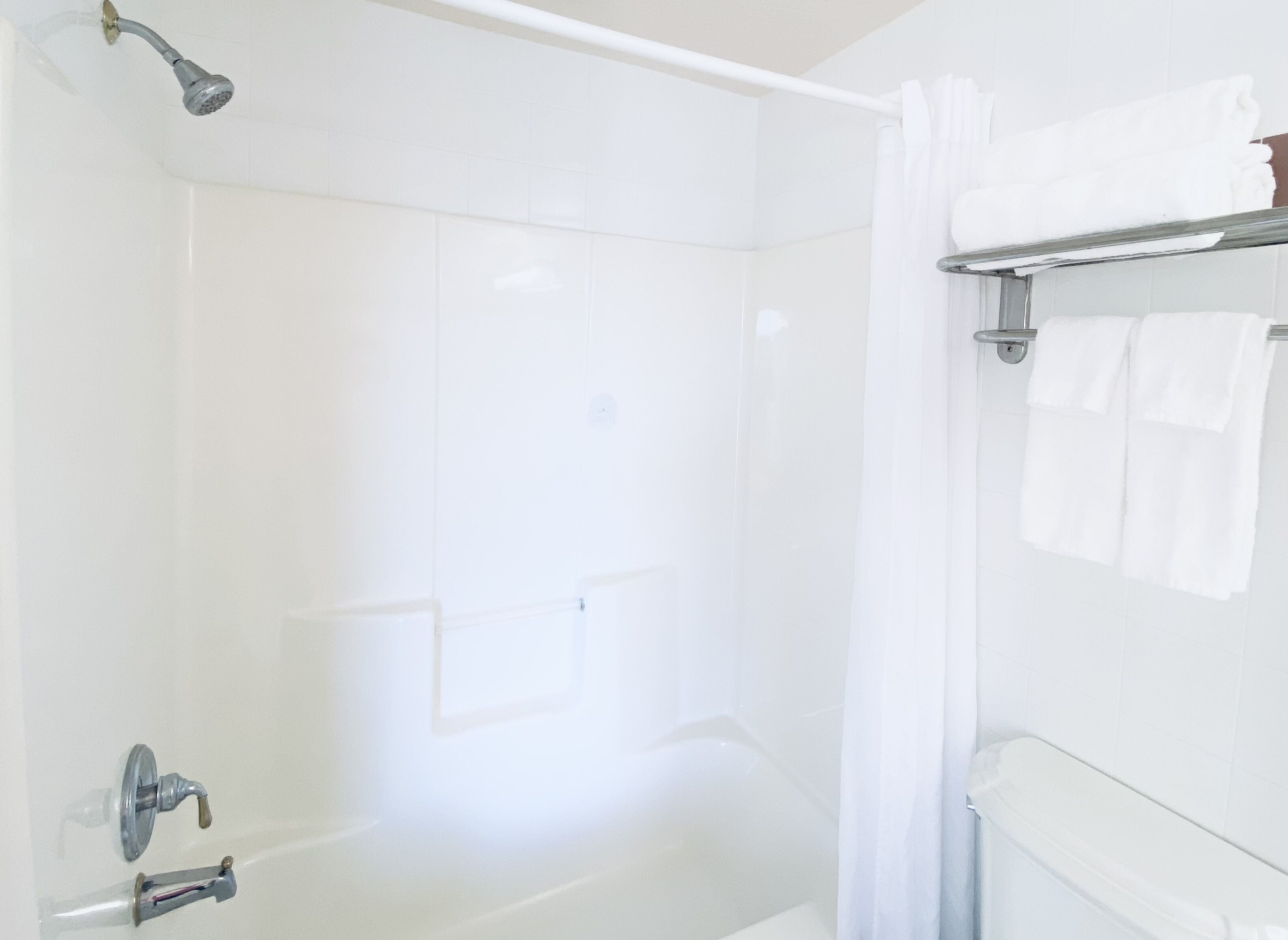 A modern bathroom with a walk-in shower, a towel rack, and a toilet.