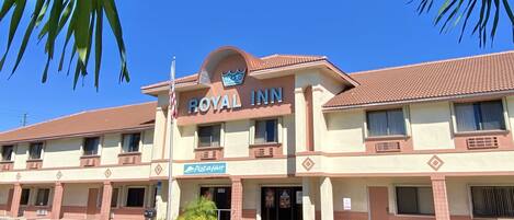 Un hôtel appelé Royal Inn, avec une enseigne indiquant la présence d’un restaurant Pizza Hut.