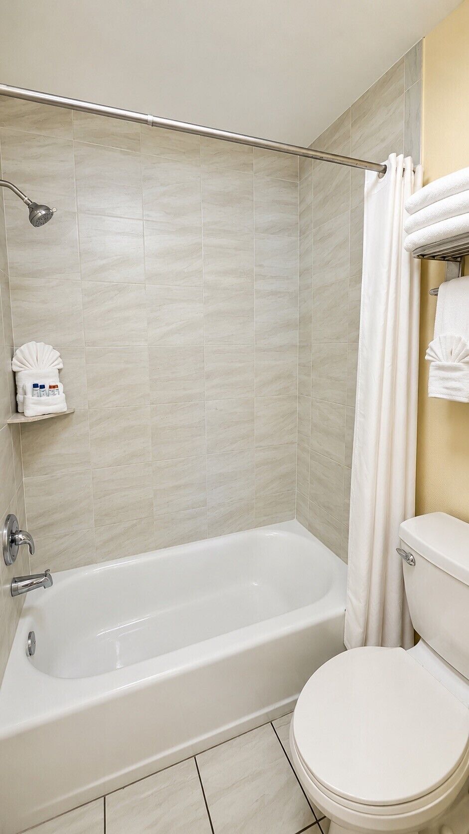 Une salle de bain avec une baignoire, des toilettes et un rideau de douche.