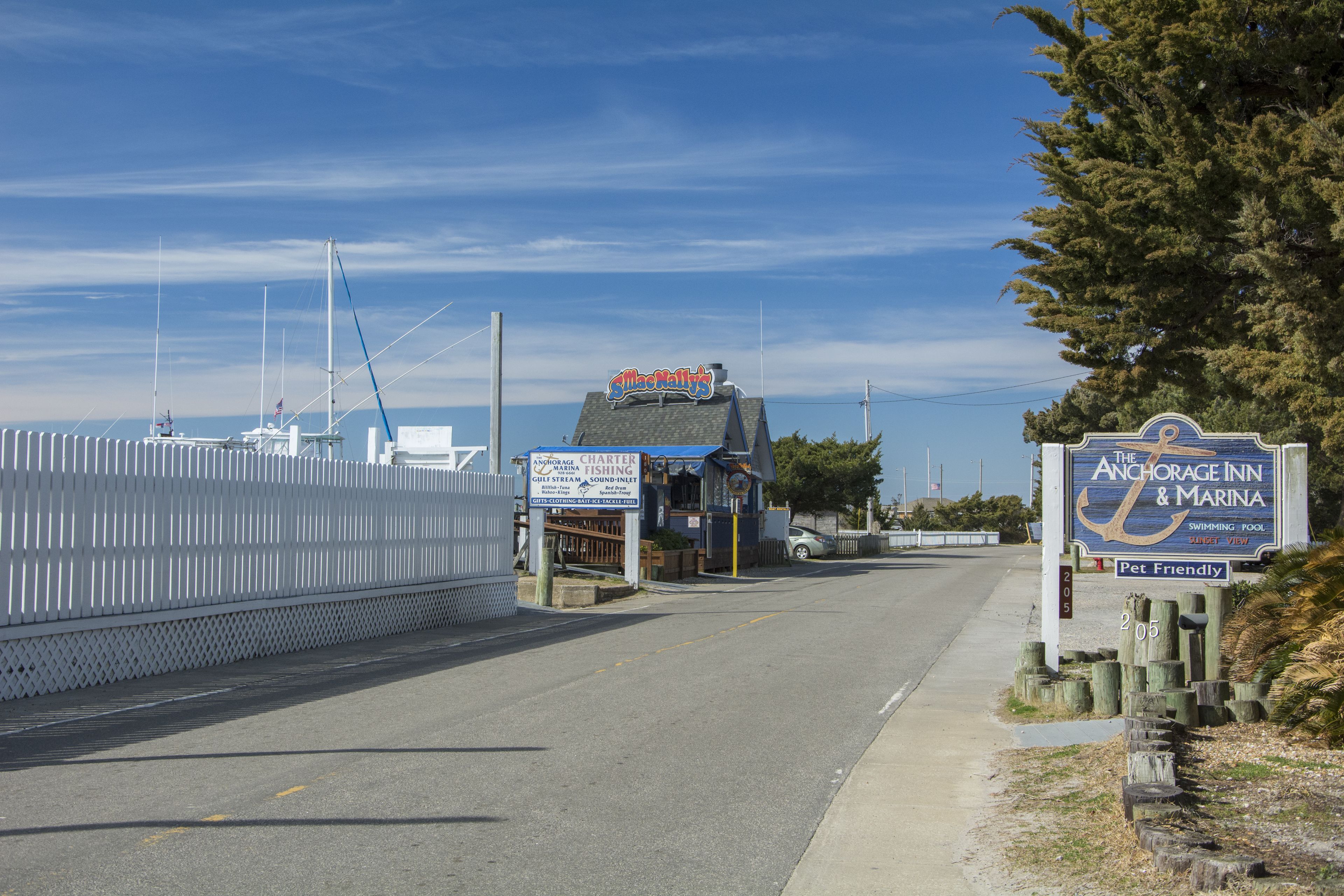 Una carretera costanera amb indicadors per 'Anchorage Inn & Marina' i 'McAlly's'.