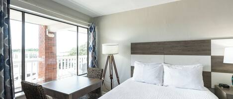 A hotel room with a bed, a desk, and a chair.