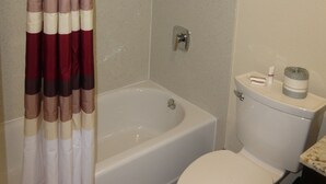 Une salle de bain avec une baignoire, des toilettes et un rideau de douche.
