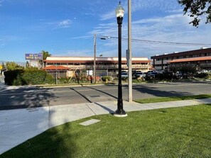 A street view with a motor hotel, a street lamp, and a parking lot. - Bel Air Motor Hotel (Tustin)