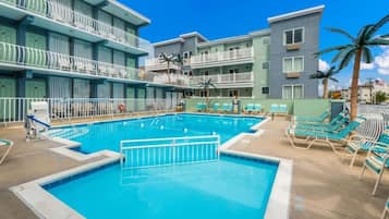 Een seizoensgebonden buitenzwembad, ligstoelen bij het zwembad