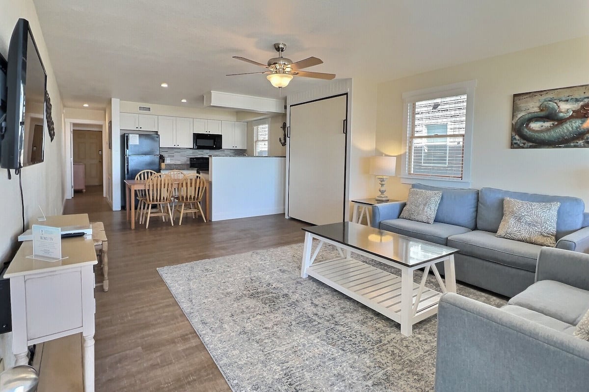 A modern apartment with a kitchen, dining area, and living room.