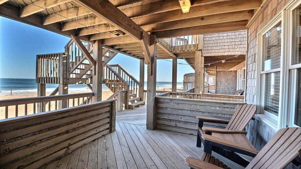 A wooden deck with a view of the beach and ocean. - Lighthouse View Oceanfront Lodging (Buxton)