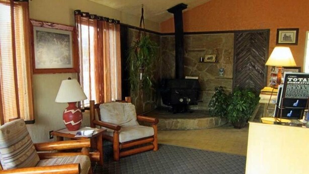 A cozy lobby with a fireplace, comfortable seating, and a reception desk. - Color Country Motel (Panguitch)