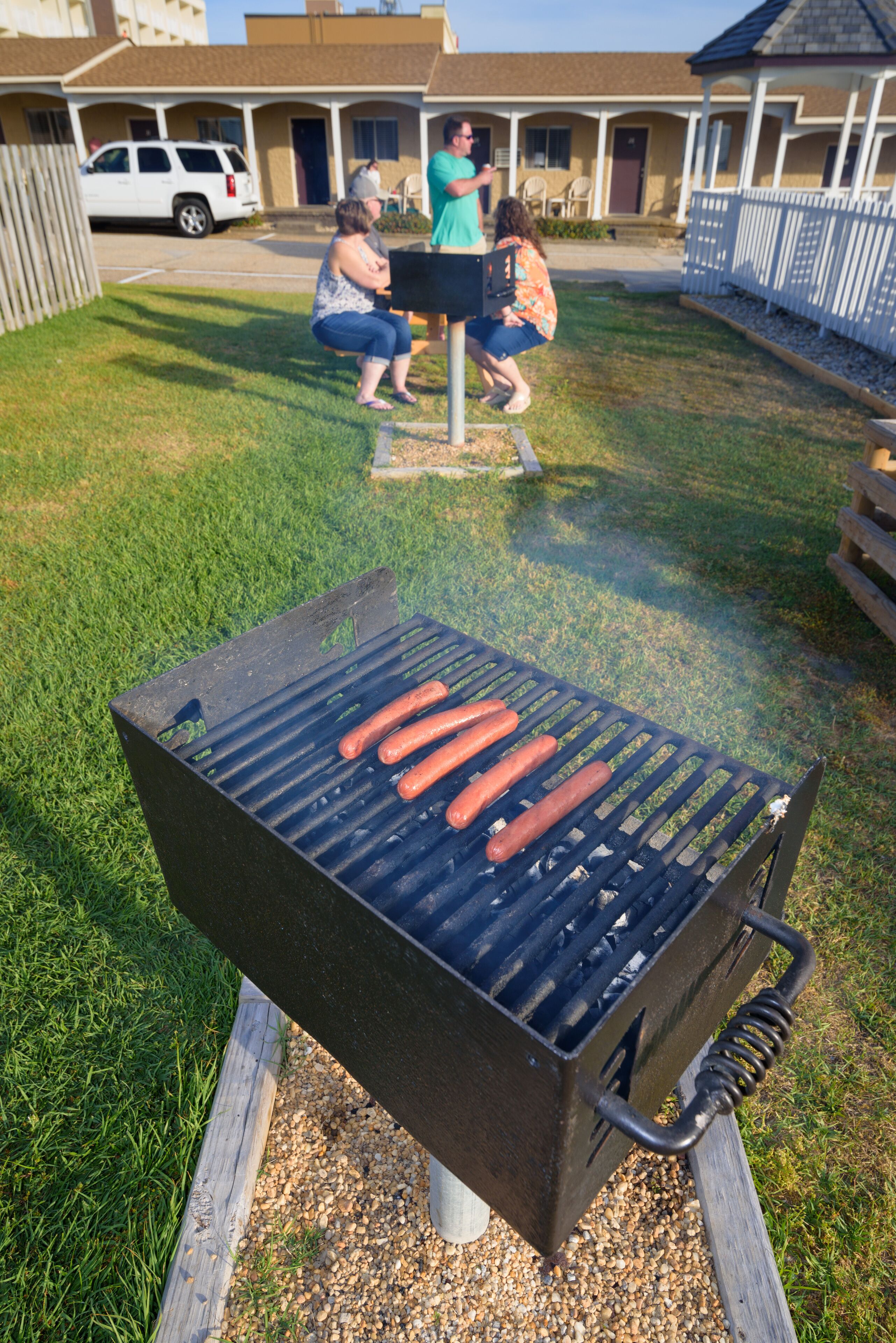 Un barbecue sur lequel on fait griller des saucisses à l’extérieur.
