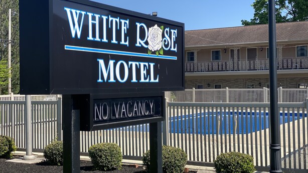 Schild des White Rose Motel mit einem 'Keine freien Zimmer'-Hinweis darunter.