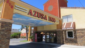 The exterior of Azusa Inn, featuring a prominent entrance with a Coca-Cola vending machine, a Coca-Cola sign, and a Night Window sign. - Azusa INN Motel (La Puente)