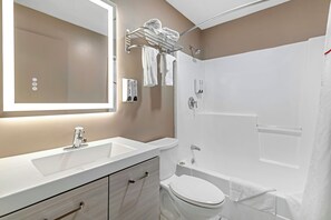 A modern bathroom with a sink, mirror, towel rack, toilet, and shower. - Red Roof Inn & Suites Swansea (Swansea)