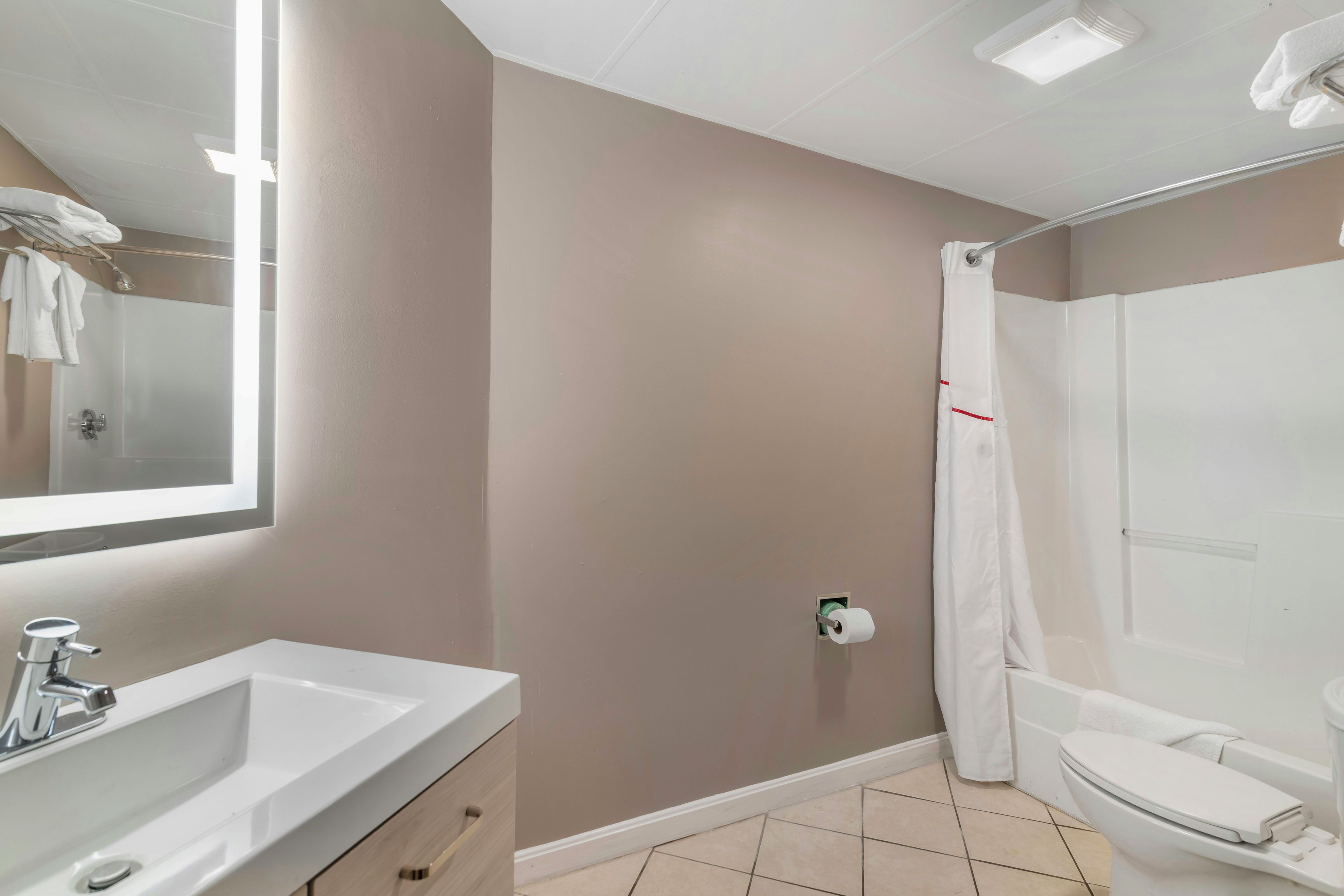 A bathroom with a sink, toilet, and shower area.
