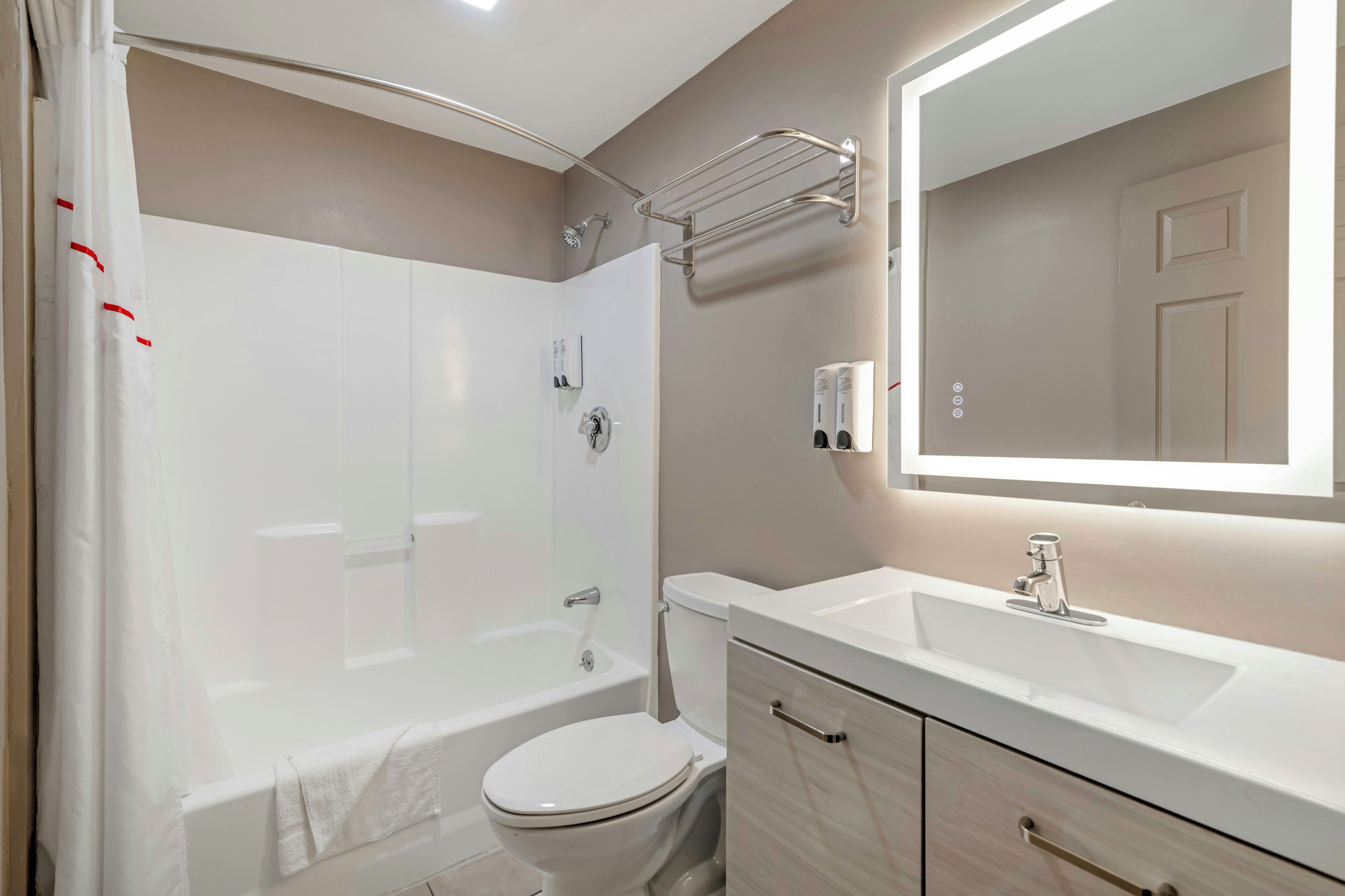 A modern bathroom with a bathtub, toilet, and vanity.