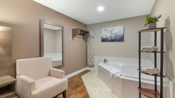 Un baño moderno con una bañera, un tocador con espejo, una silla y un estante con toallas.