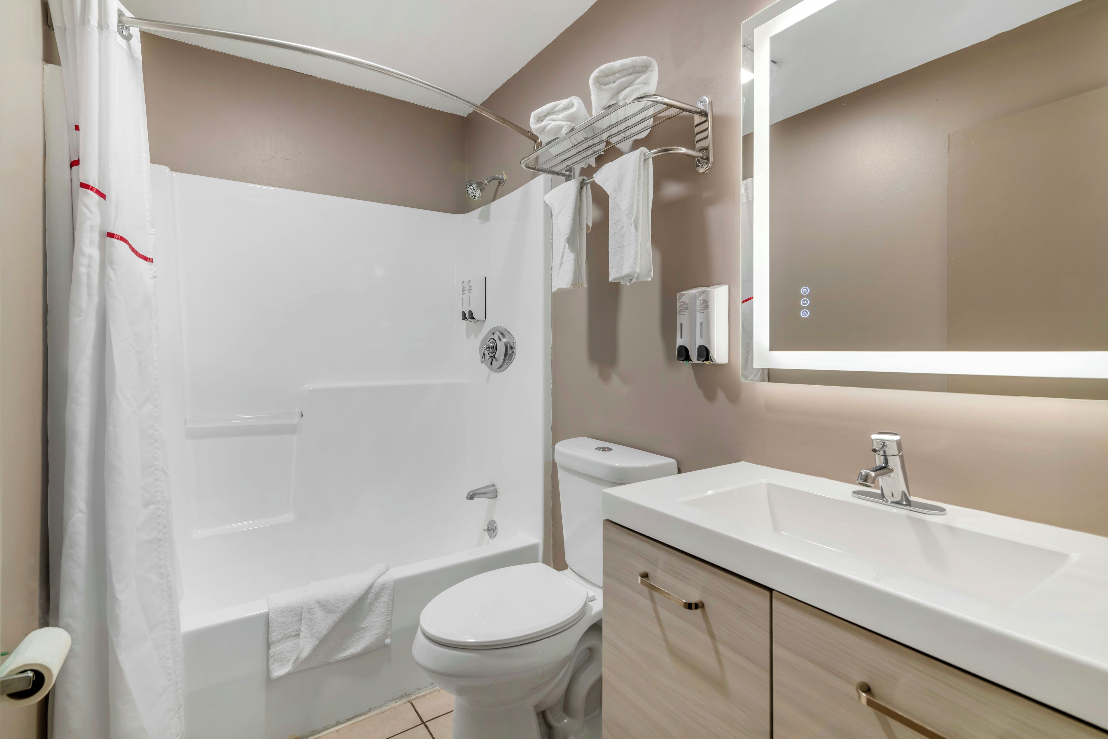 A modern bathroom with a bathtub, toilet, and sink.