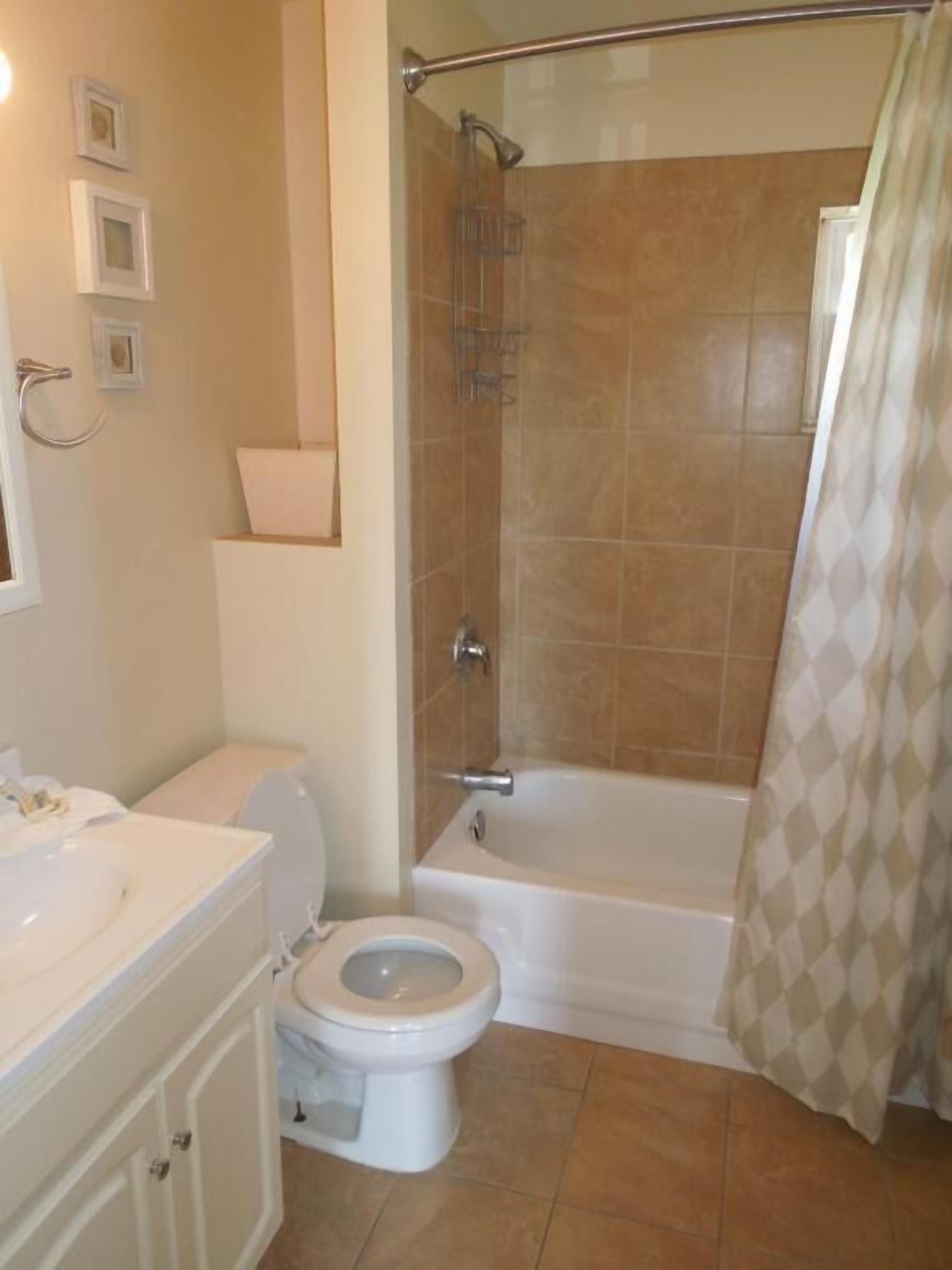 A bathroom with a toilet, sink, and bathtub.